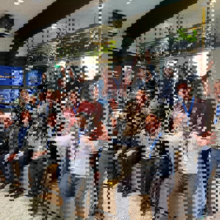 A group of 20 people form all over the world excited and smiling